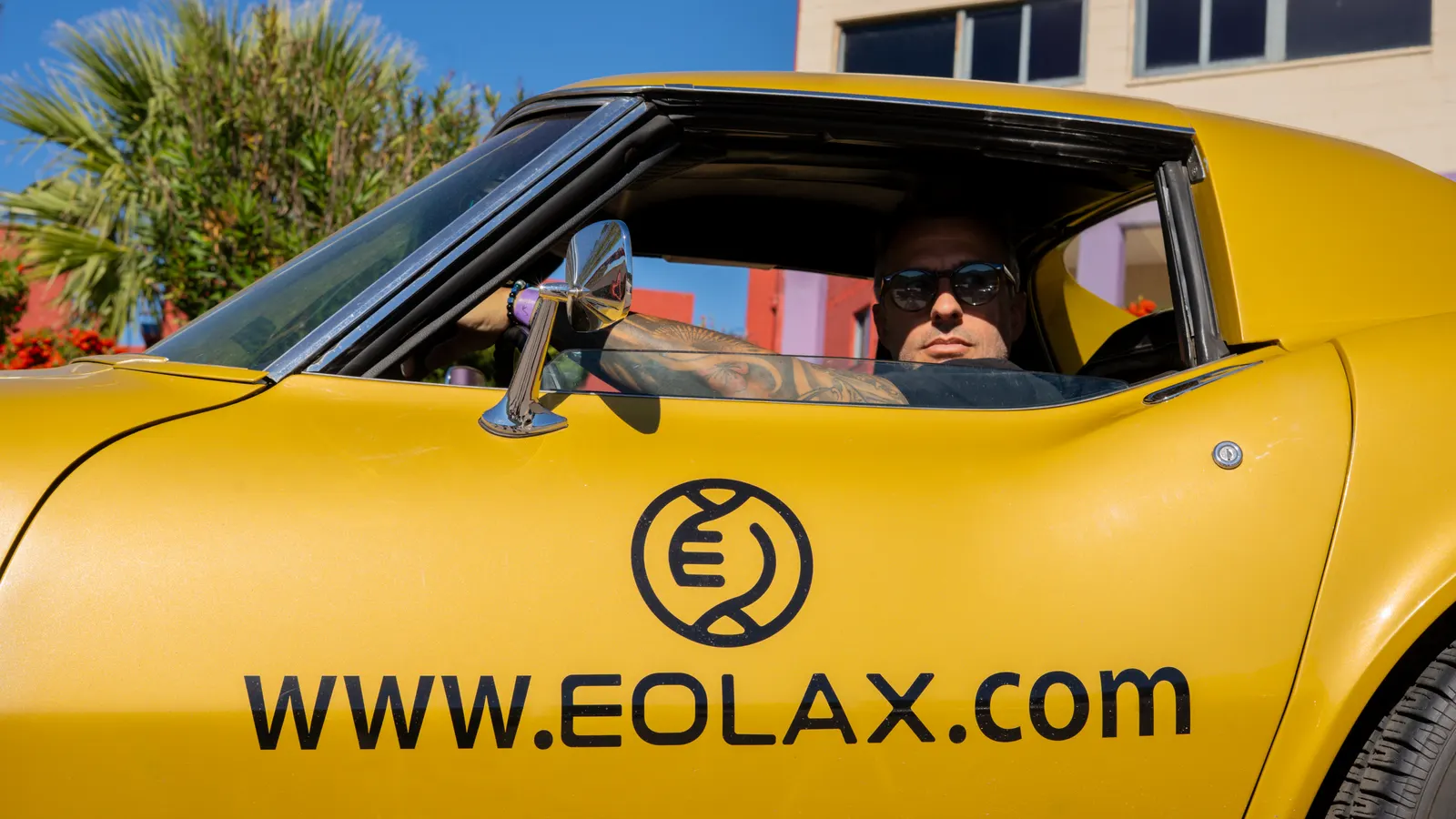 Un conductor al volante del Corvette, con el isotipo y WWW.EOLAX.COM impresos en la puerta.