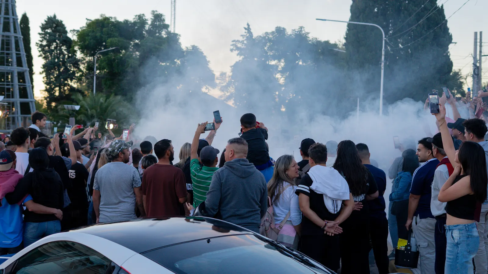 El público filma con los celulares en alto mientras una nube de humo de neumático cubre la pista.